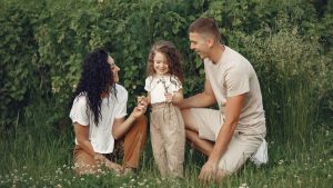 A joyful family enjoying time together in a lush green field.